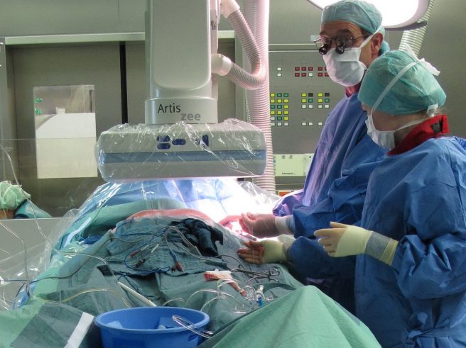 Two medical staff standing next to a patient on an operating table